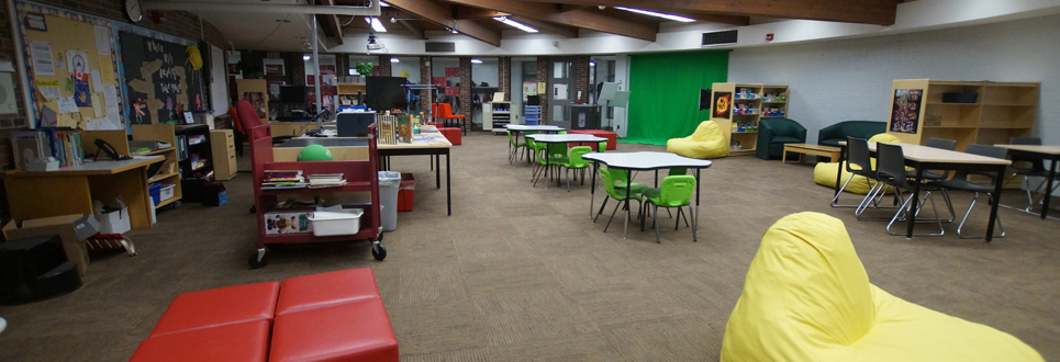 Tables, chairs, books in the Learning Commons area