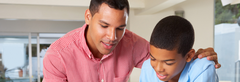 Father working on school work with son.